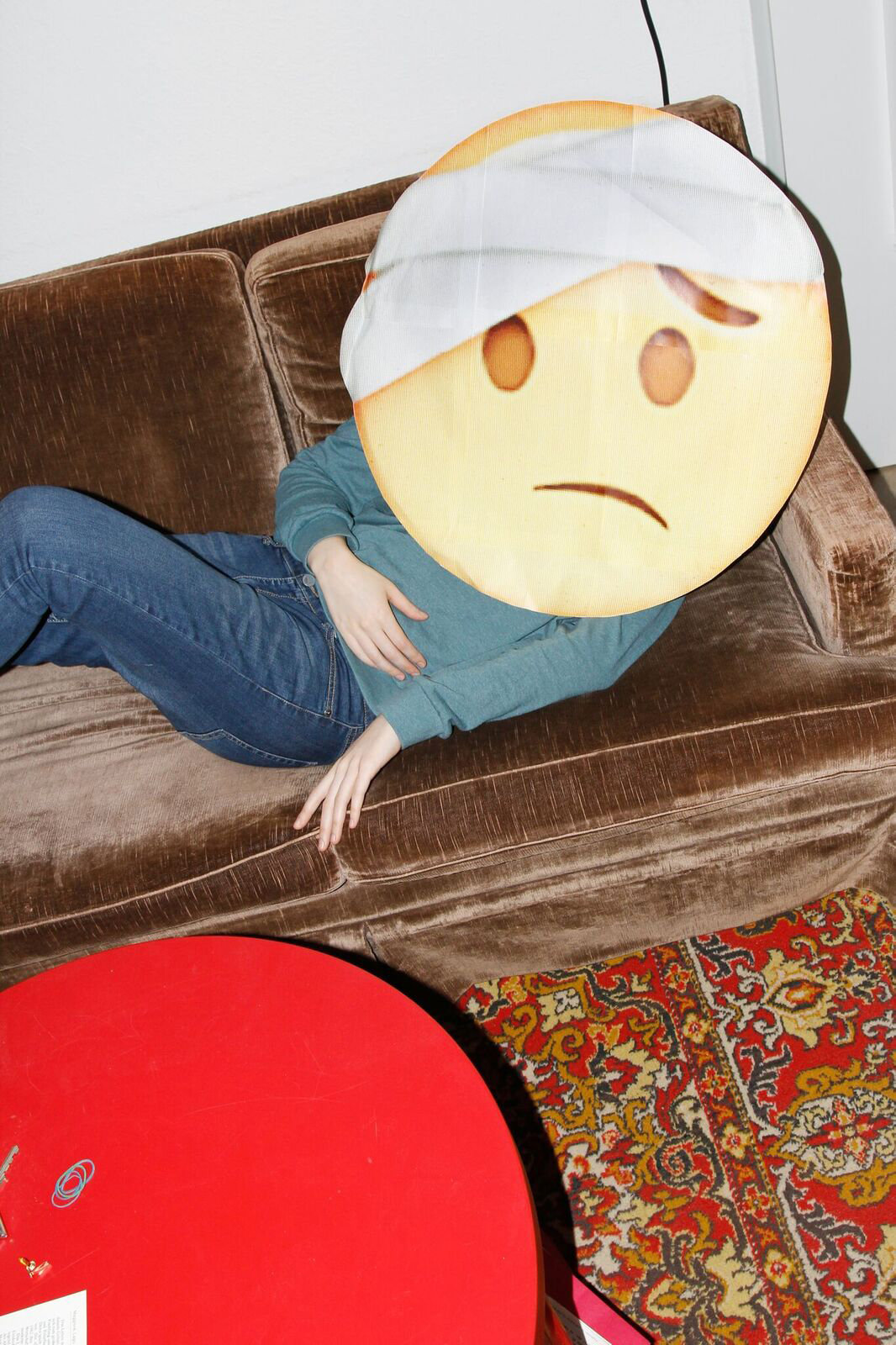 Emoji mit Kopfverband liegt auf einem Sofa (Foto: Renke Brandt)