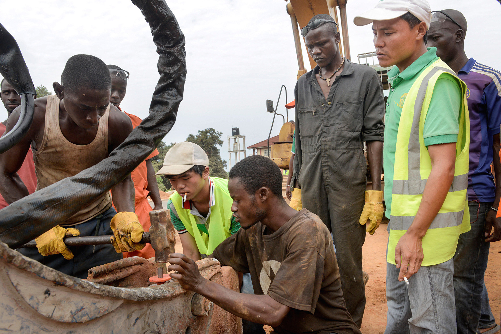 Chinesische Ingenieure auf einer Baustelle in Afrika Chinesische Ingenieure auf einer Baustelle in Afrika