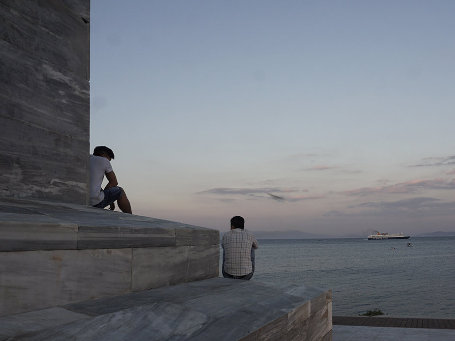 Die zwei 17-jährigen Afghanen Fadi und Saboor warten seit acht Monaten auf ihren Asylbescheid, hier sitzend auf Lesbos’ Freiheitsstatue (Foto: Franziska Grillmeier)