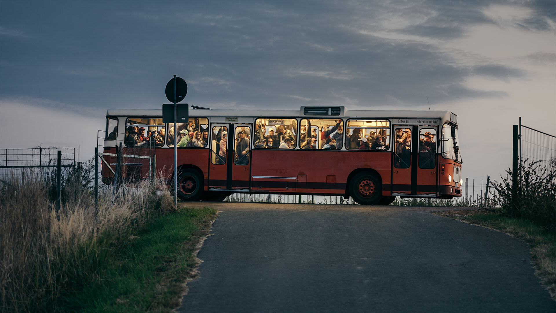 Arbeitskräfte kommen am frühen morgen mit einem alten Bus auf einer Apfelplantage in Sachsen an