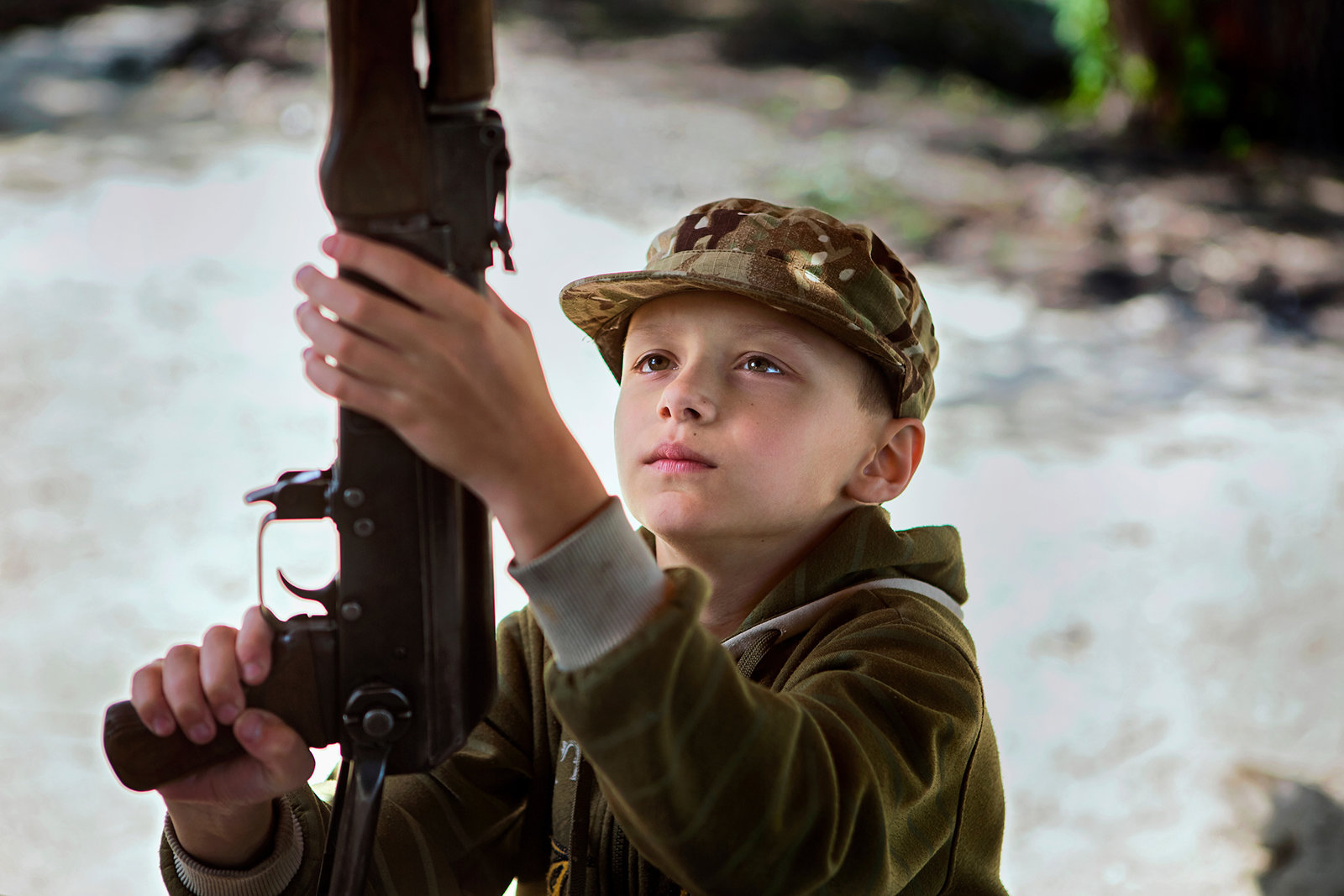 Ein Kind begutachtet seine Waffe