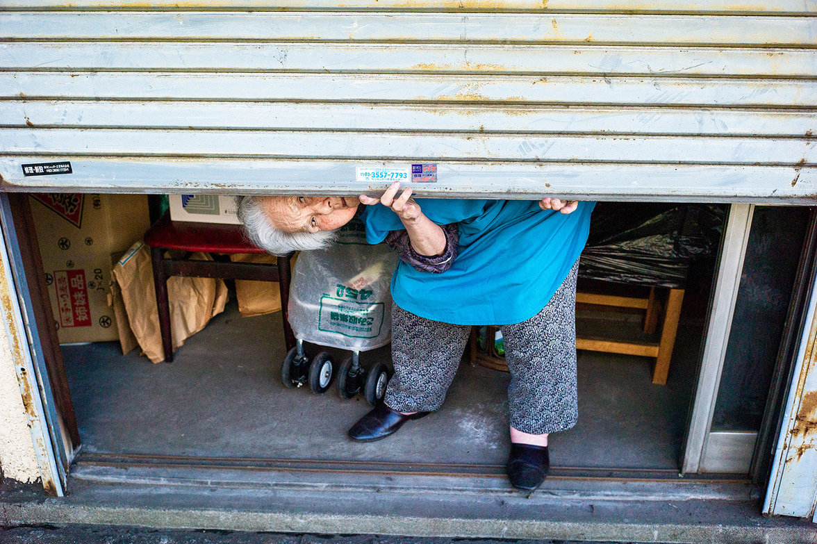 Alte Frau in einer Garage in Tokio
