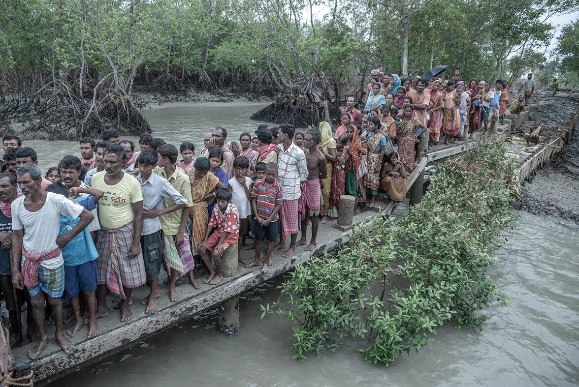 Die Dorfbewohner der Insel Sajtelia stehen Schlange, um Hilfe zu erhalten, nachdem ein Zyklon viele Häuser zerstört hat