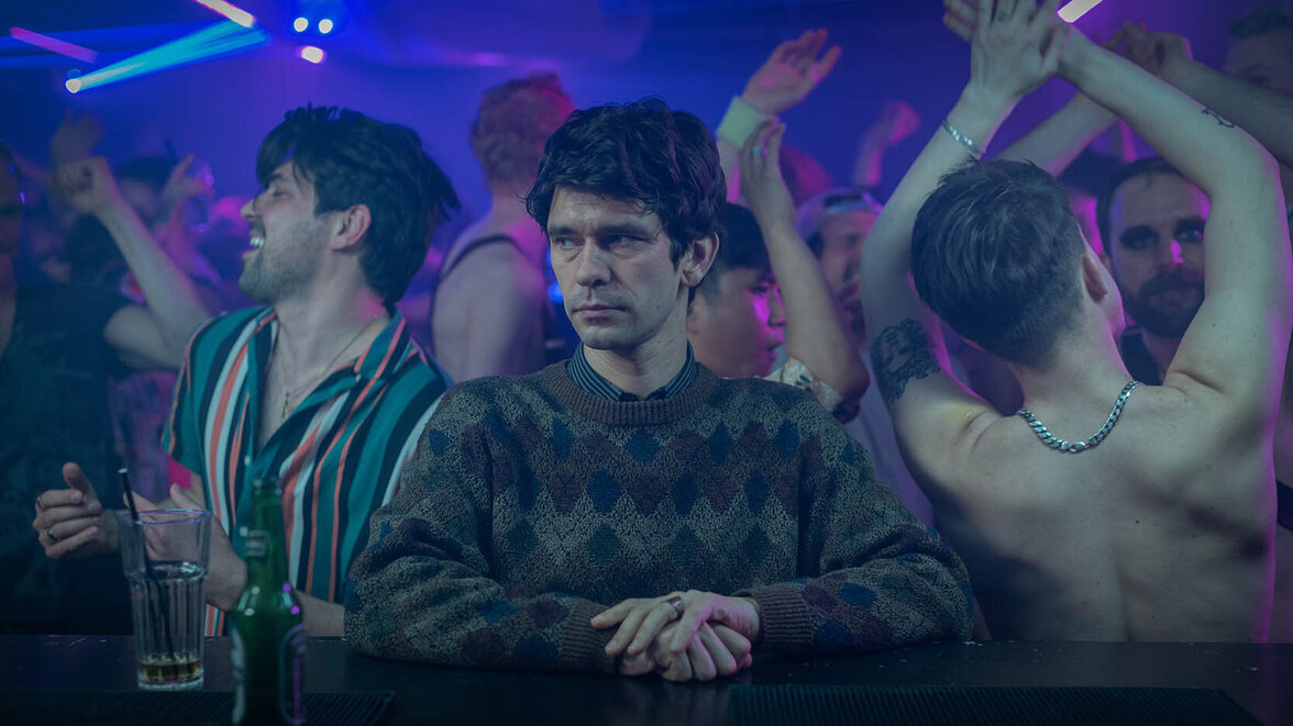 Adam (Ben Whishaw) sitzt emotionslos an einer Bar, während auf der Tanzfläche hinter ihm alle ausgelassen tanzen