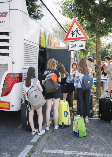Jugendliche steigen in den Reisebus
