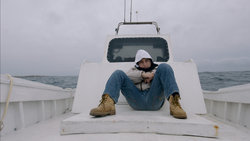 Bild aus dem Film "Fuoccoammare": Eine Person sitzt auf einem weißen Boot