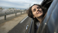Die Protagonistin Sonia (Noémie Merlant) streckt den Kopf aus dem Autofenster und blickt Richtung Himmel
