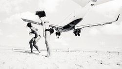 Tieffliegendes Flugzeug über zwei Frauen am Strand 