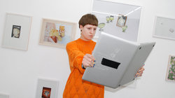 Eine Frau hält einen Laptop wie ein Buch 