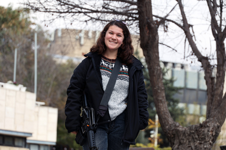 Daria Pear steht mit einem Maschinengewehr auf der Strasse Daria Pear steht mit einem Maschinengewehr auf der Strasse