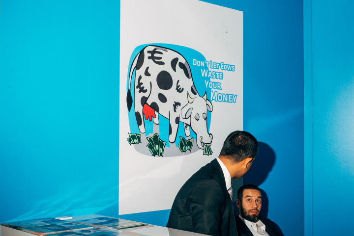 Two business men chatting in front of the “Don't let cows waste your money” booth at EuroTier trade fair. Hannover, 11/2014