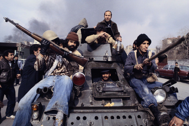 Februar 1979: Nach Khomeinis Rückkehr fahren seine Unterstützer auf einem Panzer durch Teheran Februar 1979: Nach Khomeinis Rückkehr fahren seine Unterstützer auf einem Panzer durch Teheran