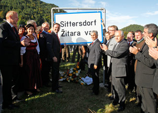 August 2011: Sogar der österreichische Kanzler kommt zur Montage der Ortstafel in Sittersdorf / Zitara vas August 2011: Sogar der österreichische Kanzler kommt zur Montage der Ortstafel in Sittersdorf / Zitara vas