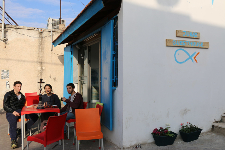 Gäste sitzen vor Juha´s Guesthouse und rauchen Shisha
