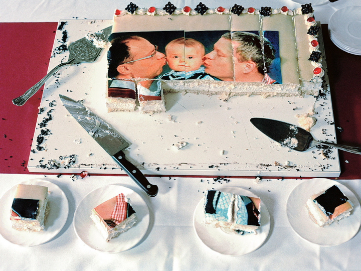 Schwule Väter und Kind auf einer Torte