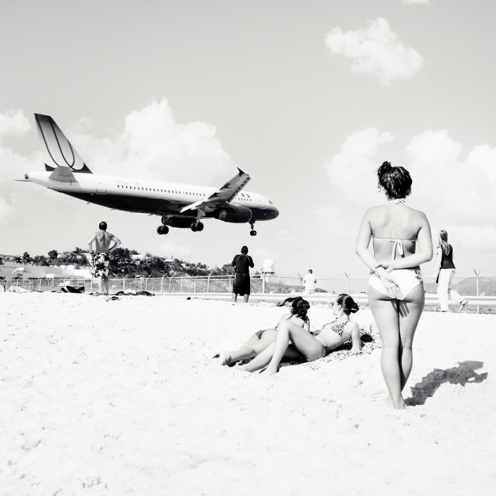 Tieffliegendes Flugzeug über Menschen am Strand Tieffliegendes Flugzeug über Menschen am Strand