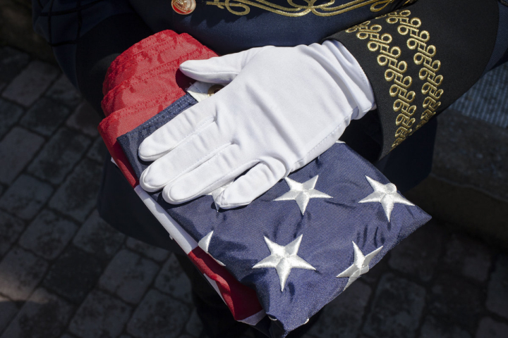 A Kosovar guard holds a US flag during the flag change ceremony that is held on July 4 of each year next to the statue of Bill Clinton in Prishtina as a commemoration of the United States Independence Day. This ceremony is organized by the Association of