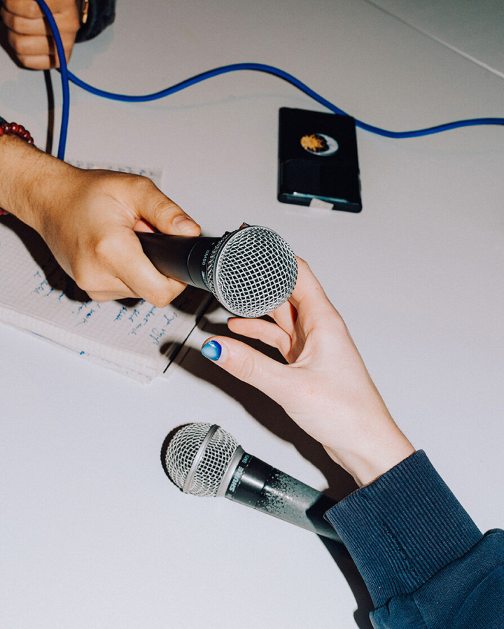 Zwei Hände reichen sich ein Mic Zwei Hände reichen sich ein Mic
