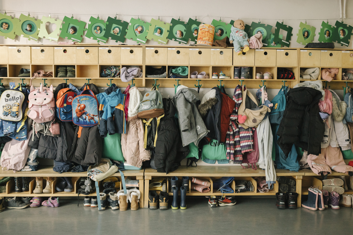 Jacken der Kita Kinder hängen an der Garderobe