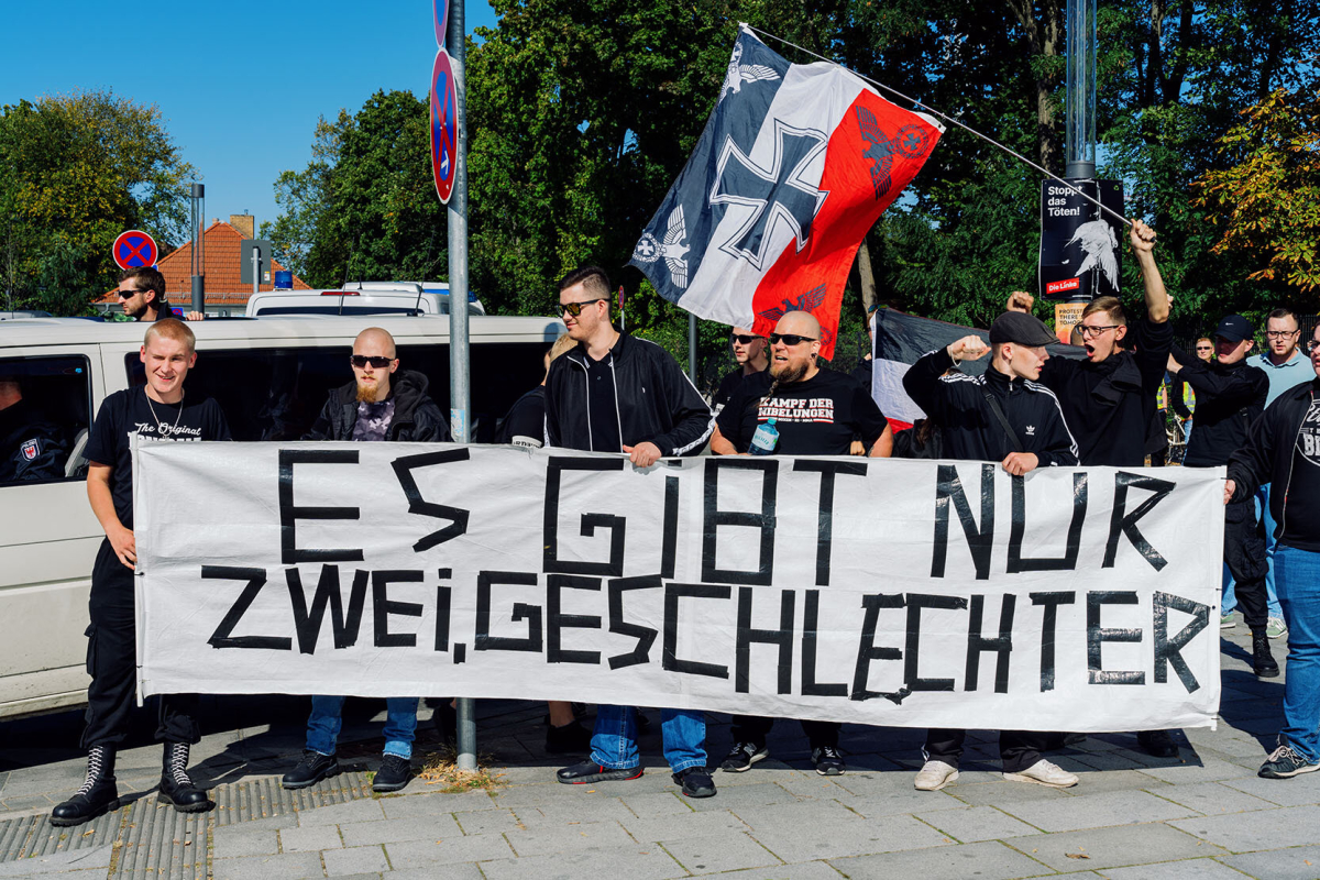 Rechtsextreme hinter einem Banner mit der Aufschrift „Es gibt nur zwei Geschlechter“. Rechtsextreme hinter einem Banner mit der Aufschrift „Es gibt nur zwei Geschlechter“.