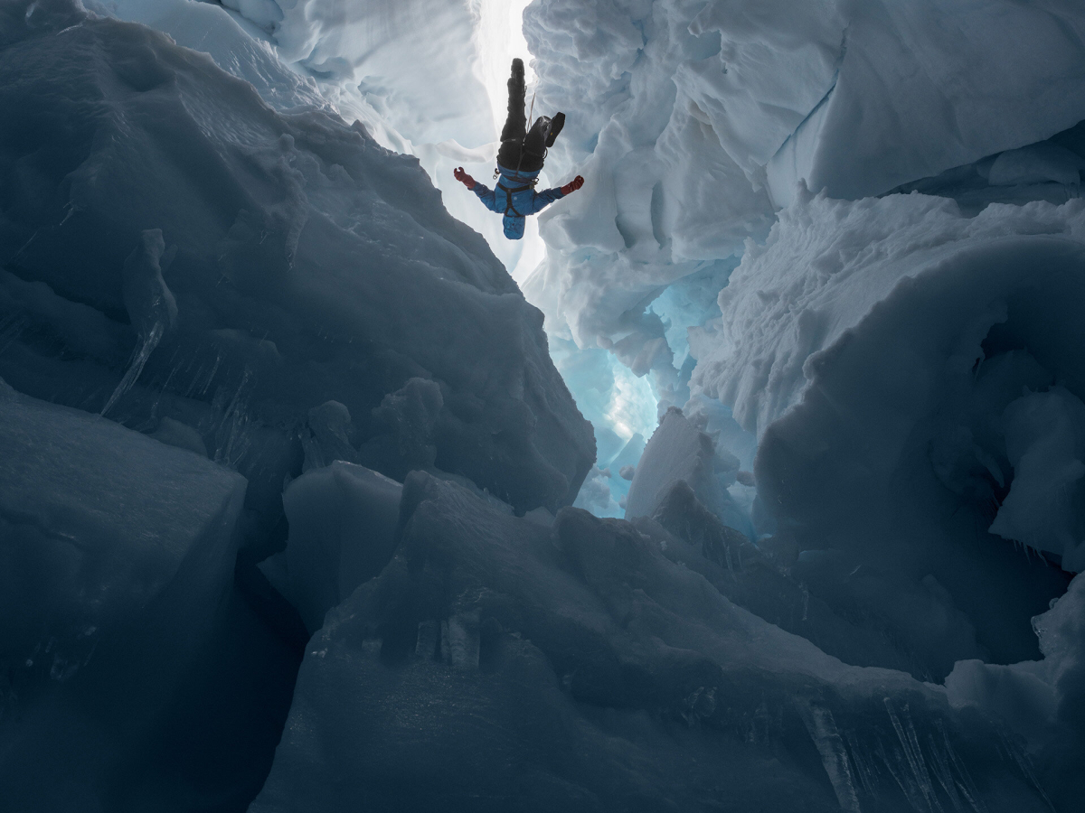 Eine Frau klettert in einen Eisberg Eine Frau klettert in einen Eisberg