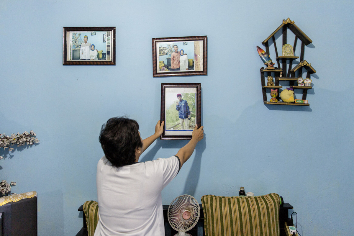 Ibu Yanti mit einem Bild ihres Sohnes Ibu Yanti mit einem Bild ihres Sohnes