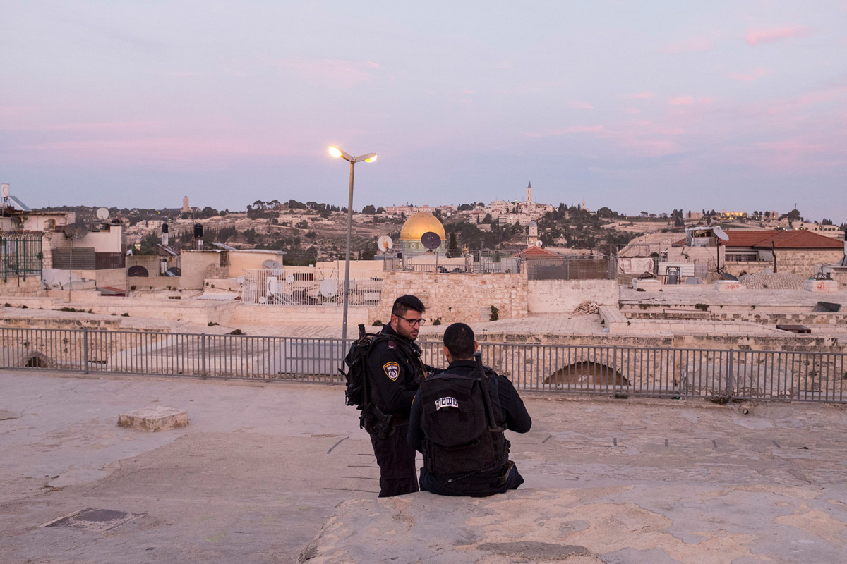 Two policemen seat and rest on the rooftops