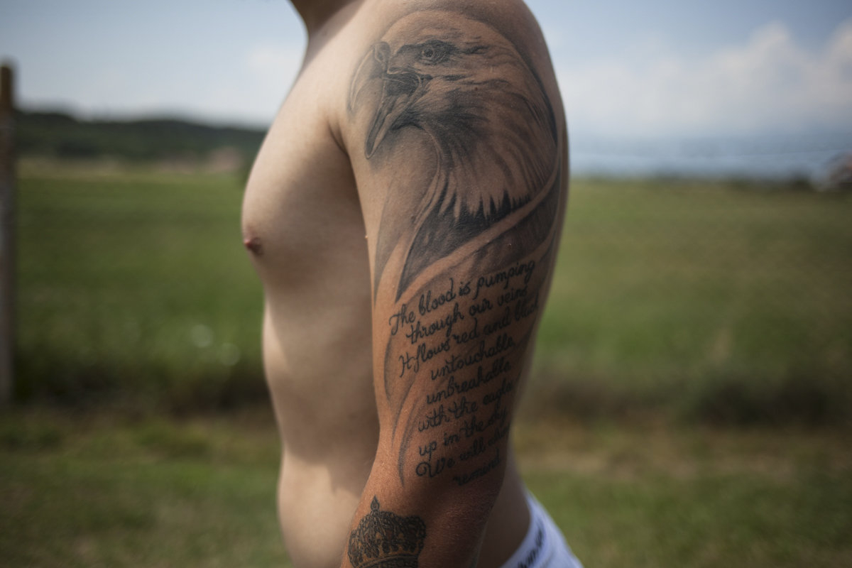 Arlind Basha wears on his left arm a tattoo of an eagle with verses that refer to the Albanian-Kosovar national identity, written in English. The eagle is a patriotic symbol for both Albanians and Americans, with the difference that the Albanian eagle sym Arlind Basha wears on his left arm a tattoo of an eagle with verses that refer to the Albanian-Kosovar national identity, written in English. The eagle is a patriotic symbol for both Albanians and Americans, with the difference that the Albanian eagle sym