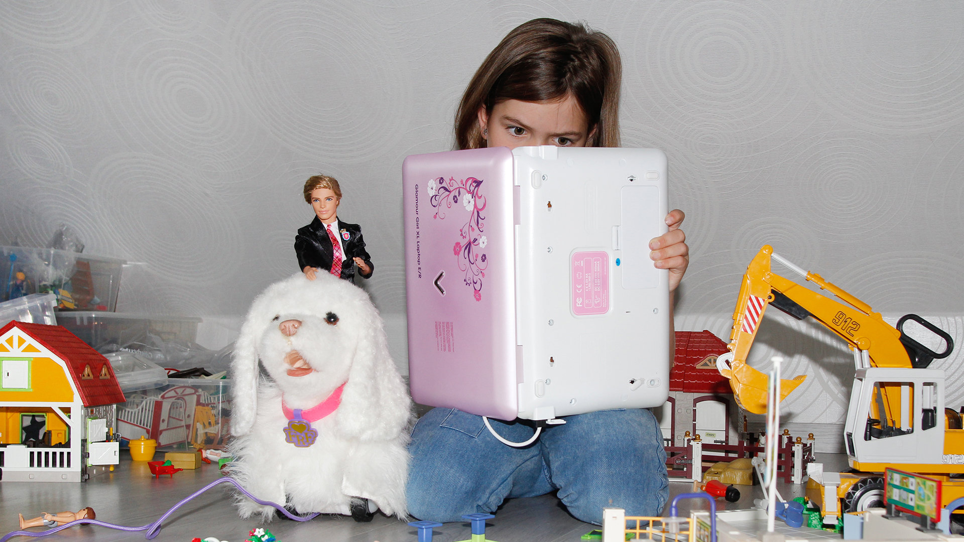 Mädchen im Kinderzimmer liest in einem Kinder-Laptop Mädchen im Kinderzimmer liest in einem Kinder-Laptop