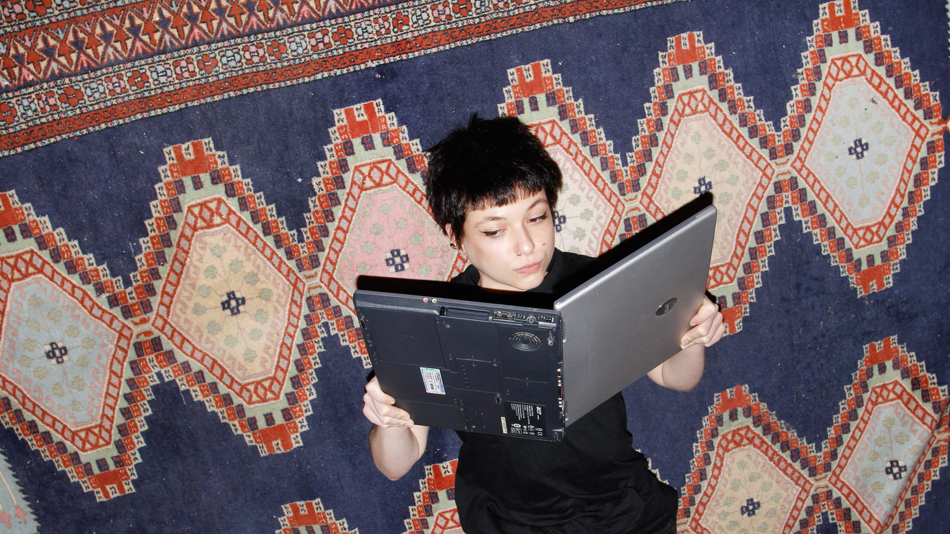 Eine Frau hält ihren Laptop wie ein Buch und liest darin Eine Frau hält ihren Laptop wie ein Buch und liest darin