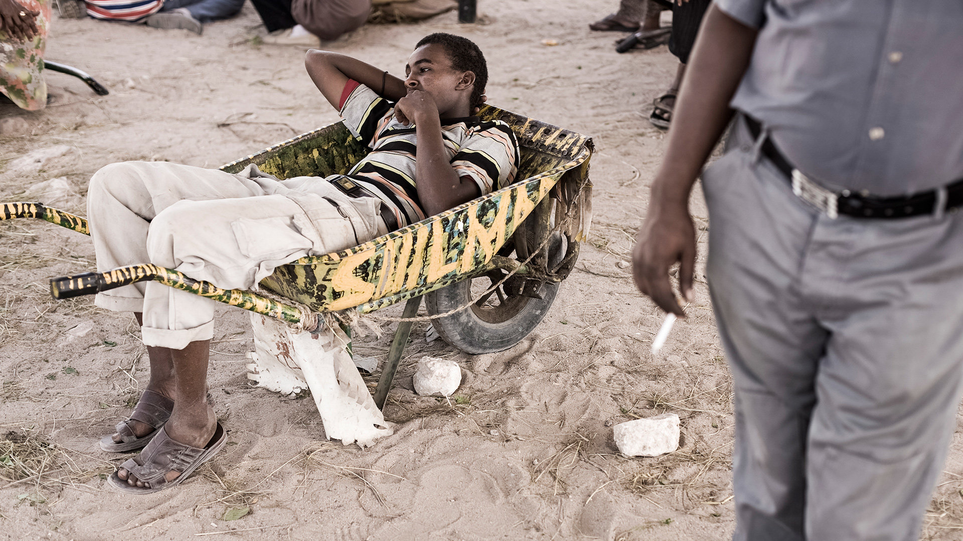 Ein Somaliländer liegt in einer Schubkarre und kaut Khat