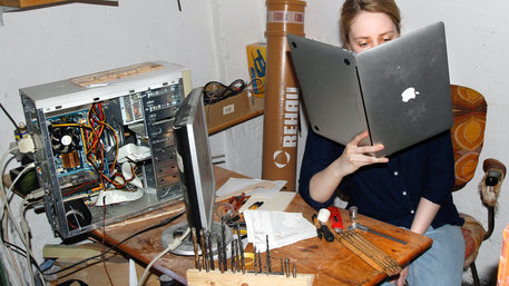 Frau liest in einem Laptop wie in einem Buch