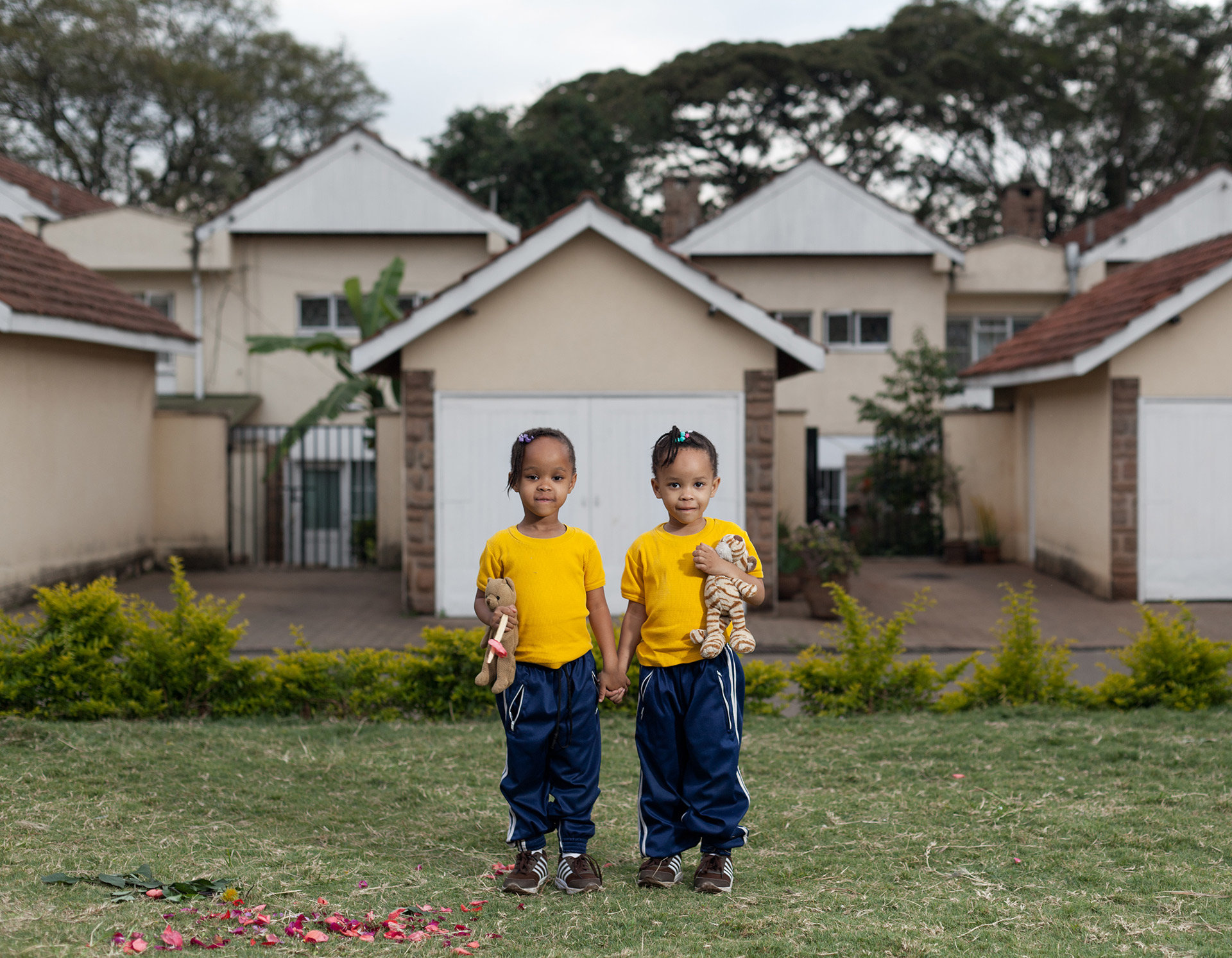 Die Zwillinge Ayanda und Anele spielen vor dem Haus ihrer Eltern. Ein typisches Reihenhaus in einer Gated Community.