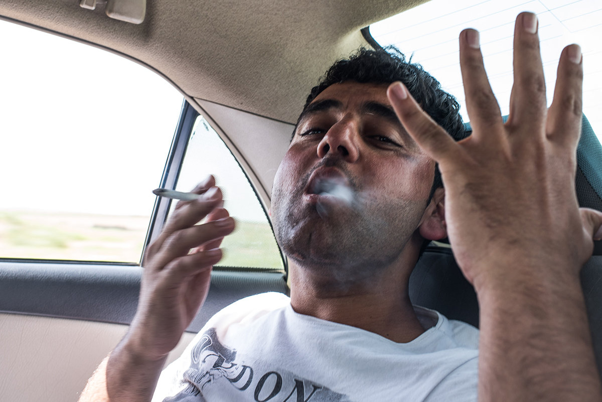 Idriss Ayl Ein rauchender Mann auf dem Rücksitz eines Autos (Foto: Chris Grodotzki)
